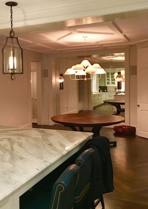 Panelled Residence — Across the marble island to the dining end. The stone top returns to meet the cabinetry, with a lantern