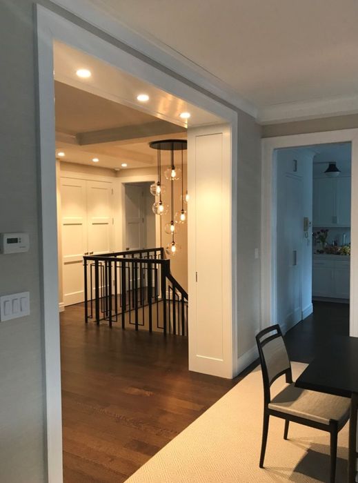 Upper Floor Residence — The passage and the black-railed stair, kept open through the plan